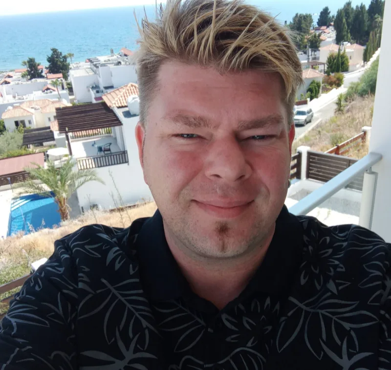 Christian, Gastgeber der Coral Bay Holiday Villas, auf einem Balkon mit Meerblick in Coral Bay