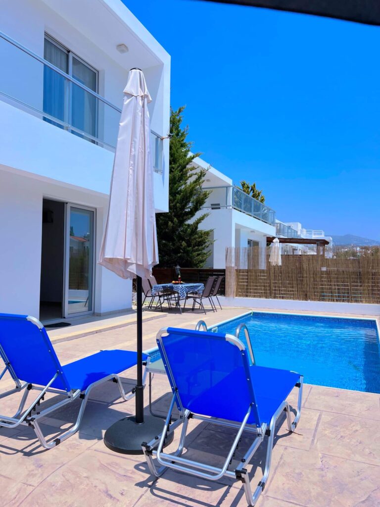 Pool und Sonnenliegen an der Villa Halia
