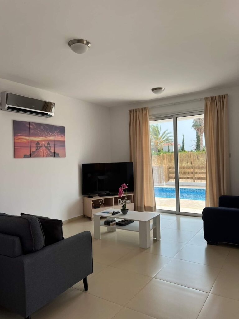 Wohnzimmer mit Sofa und Blick zum Pool