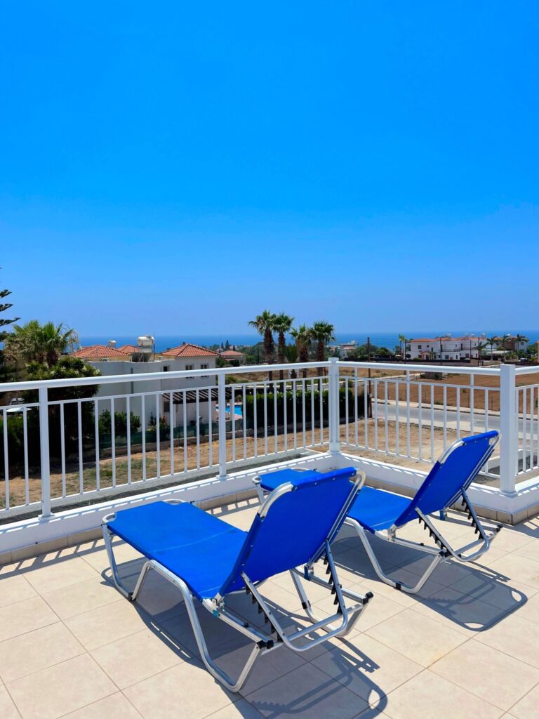 Dachterrasse mit Liegen und Blick über Coral Bay