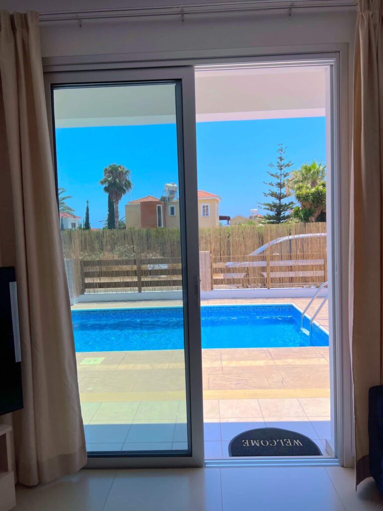 Blick durch die Terrassentür auf den Pool